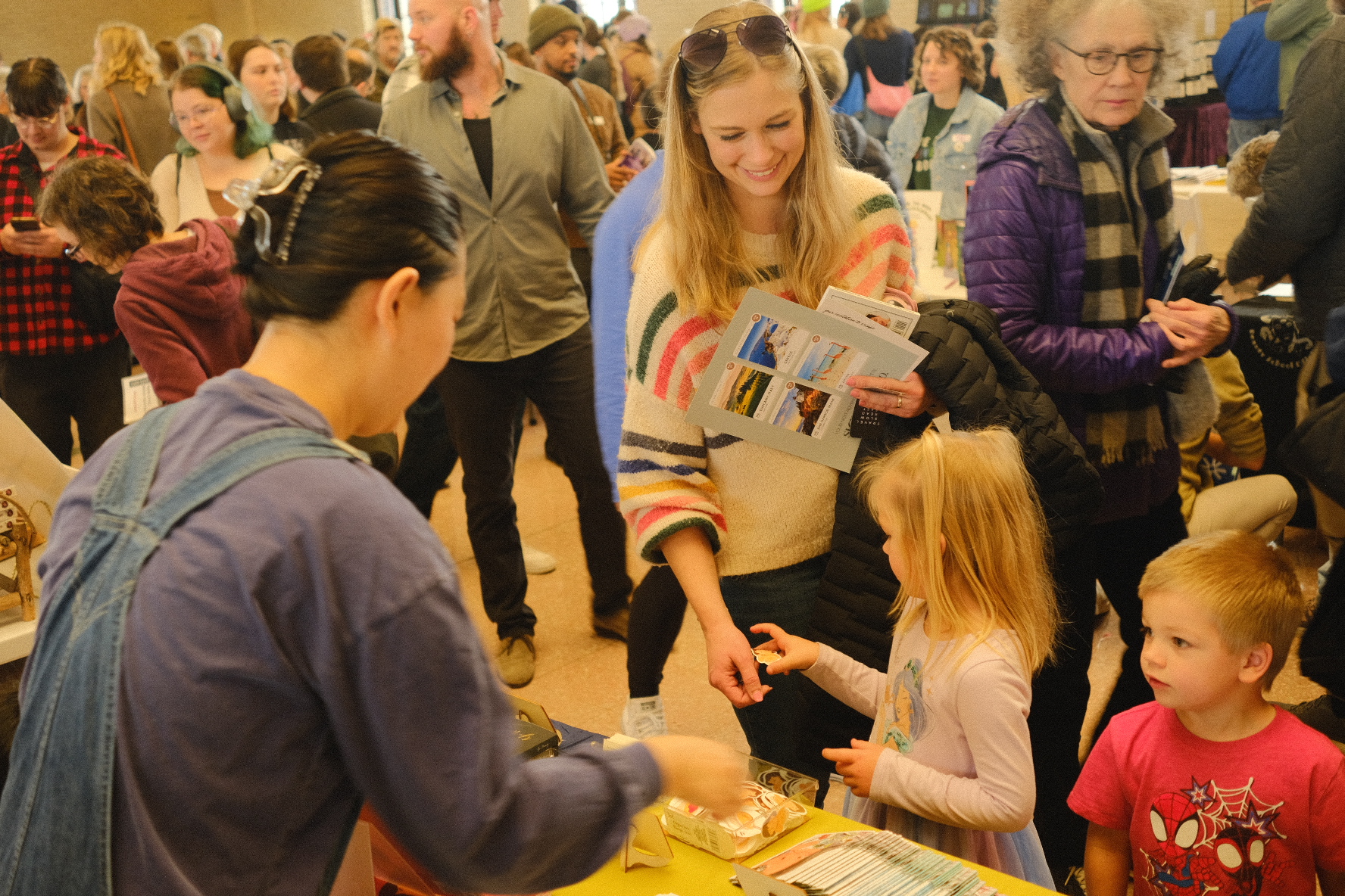 A young reader receiving a free sticker across the table