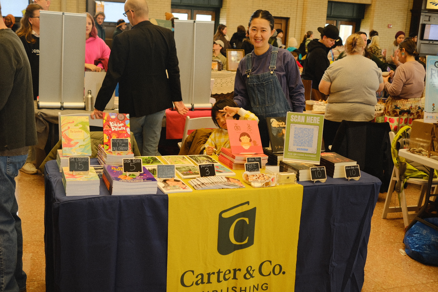 The Carter & Co. table at the Twin Cities Book Festival, with the yellow-and-navy banner and all four imprints on display